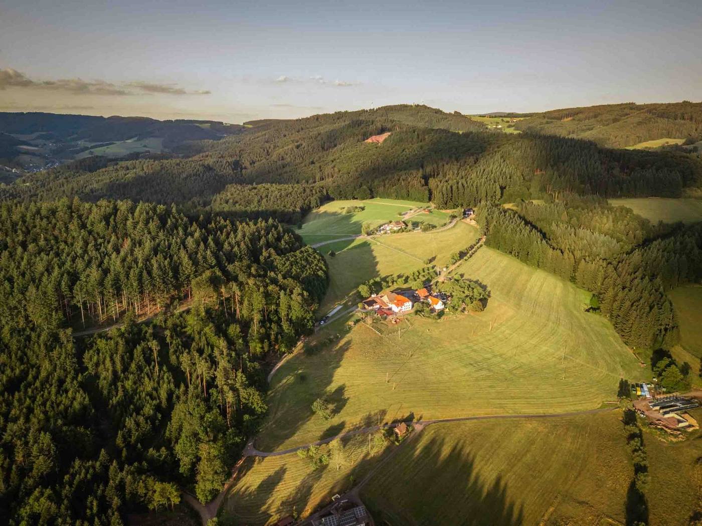Grub-Daniel-Hof im Abendlicht, Luftaufnahme mit Schwarzwald im Hintergrund
