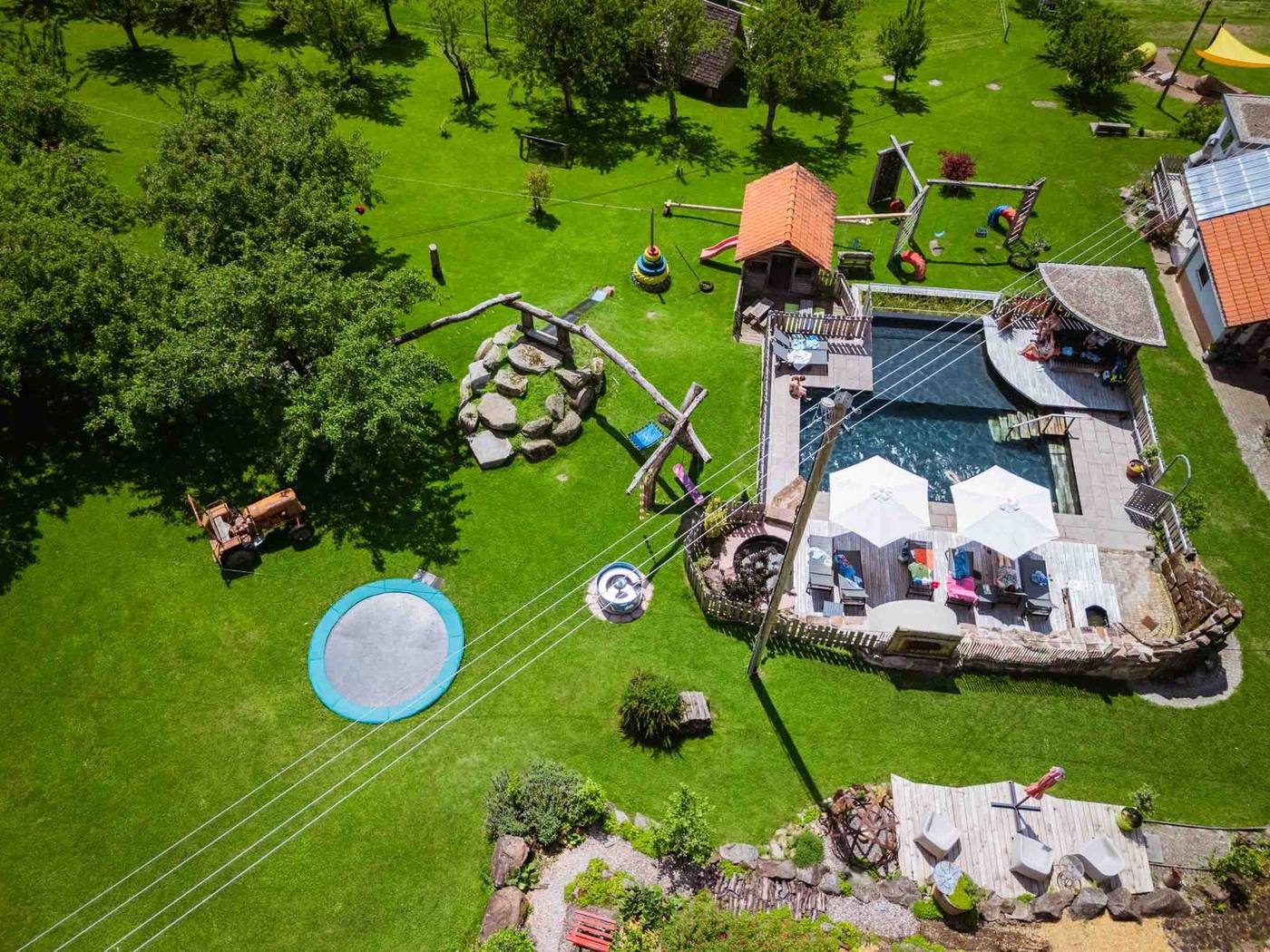 Naturpool und Spielplatz aus der Vogelperspektive