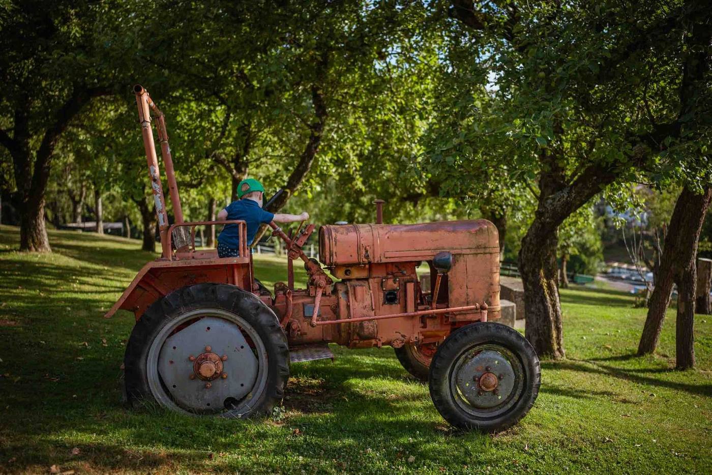 Kind auf dem roten Trettraktor