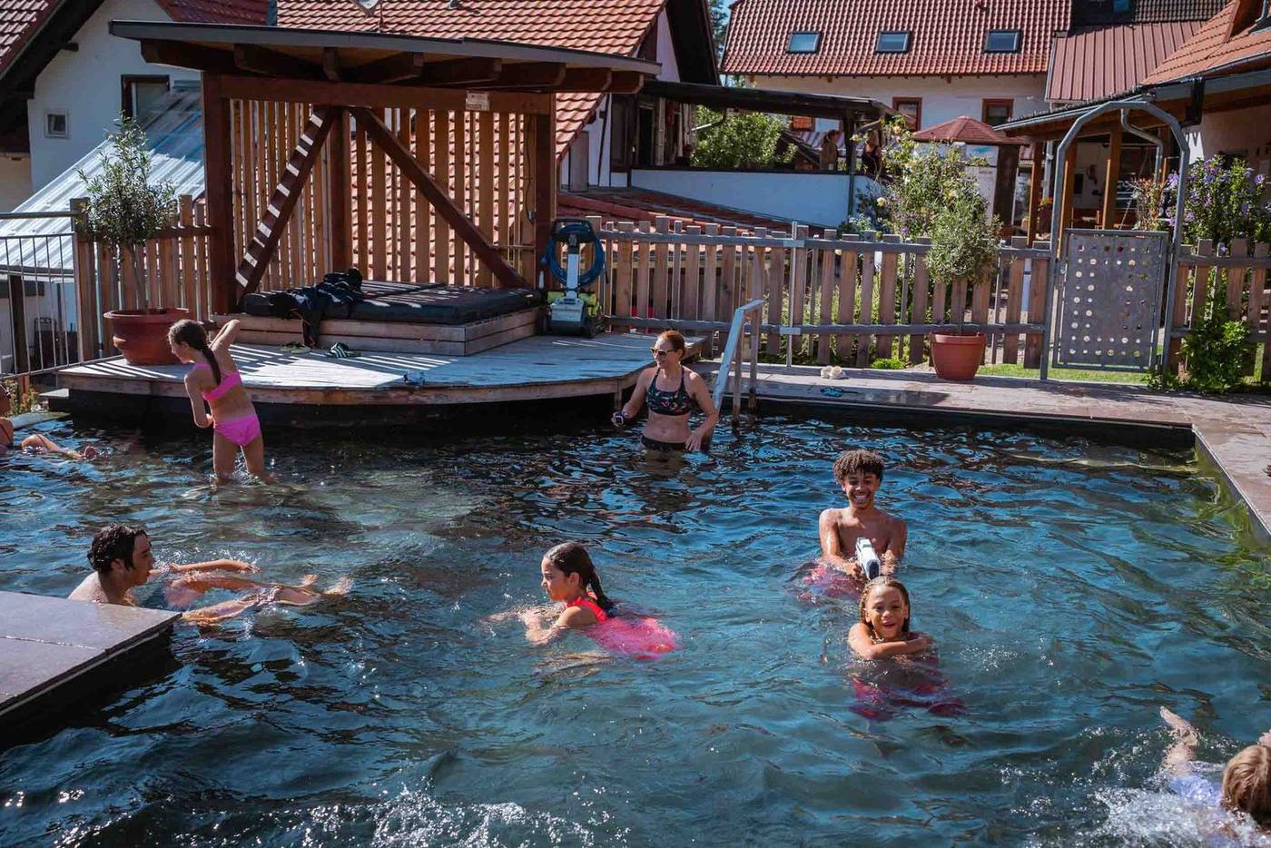 Familien planschen gemeinsam im Naturpool