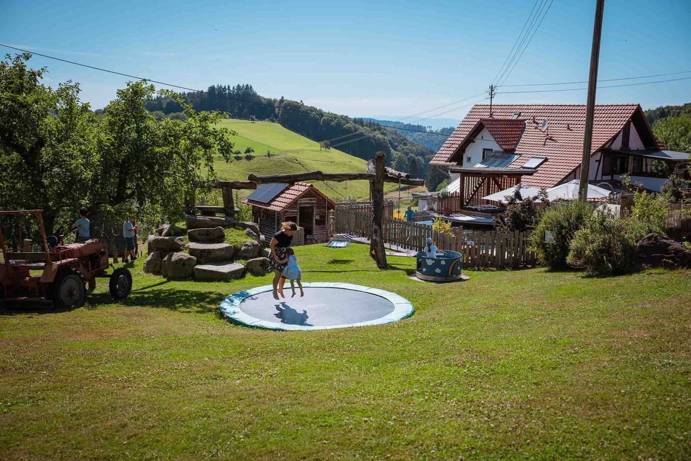 Aussicht auf Spielplatz, Trampolin und Naturpool