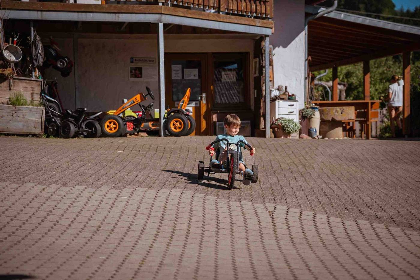 Kind fährt mit dem Trike über den Hof