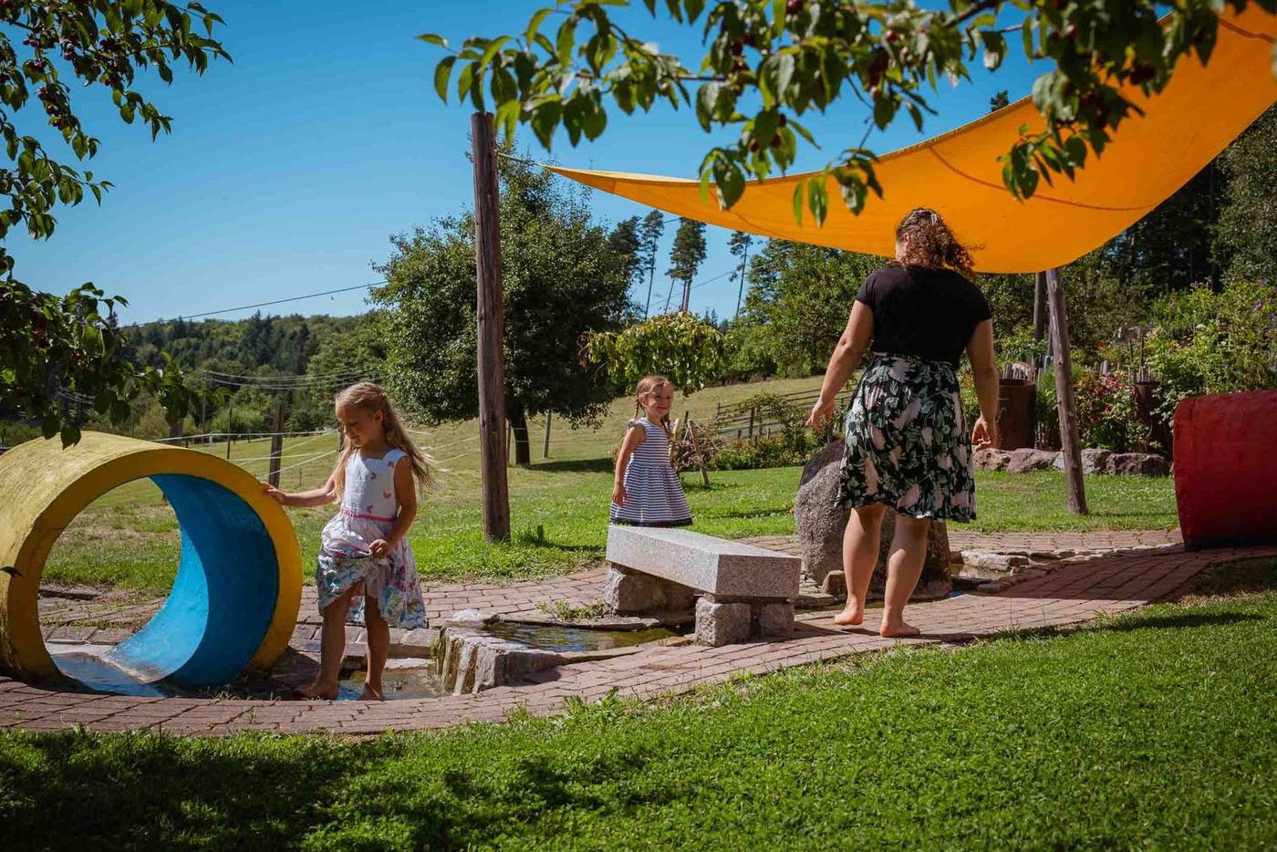 Kinder toben am Wasserspielplatz