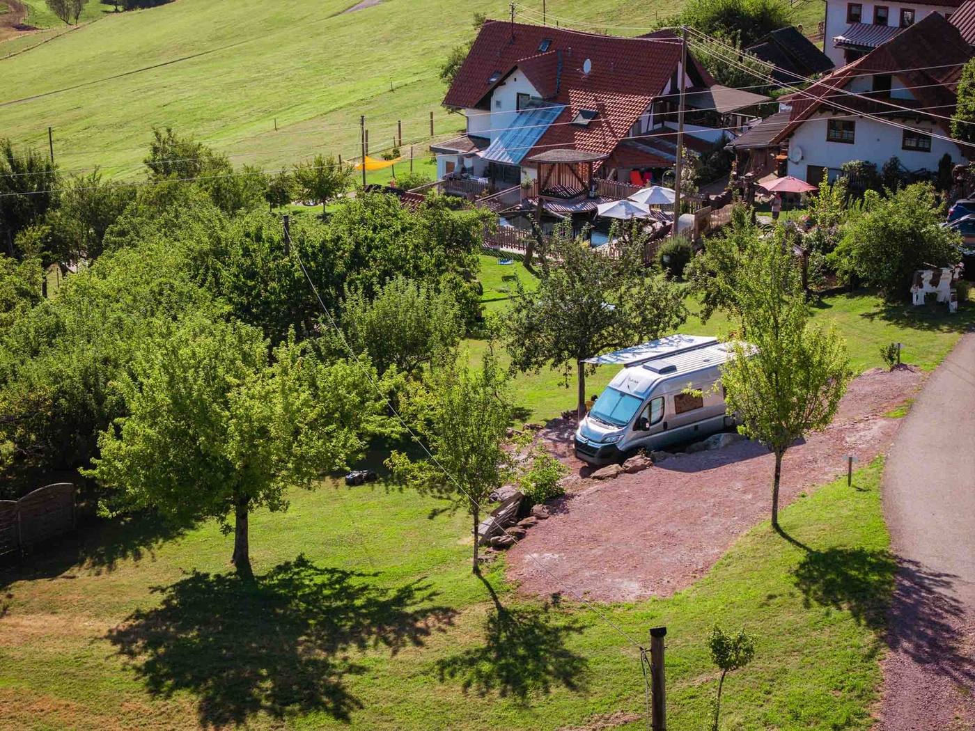 Vogelperspektive auf Hof, Naturpool und Camper-Stellplatz